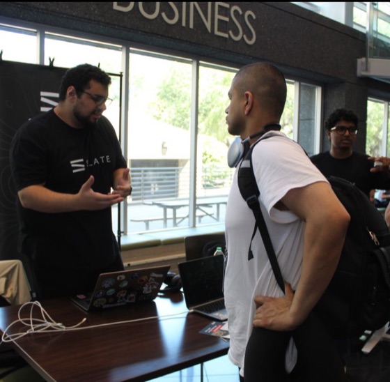Hatem demoing Slate to a student at the booth